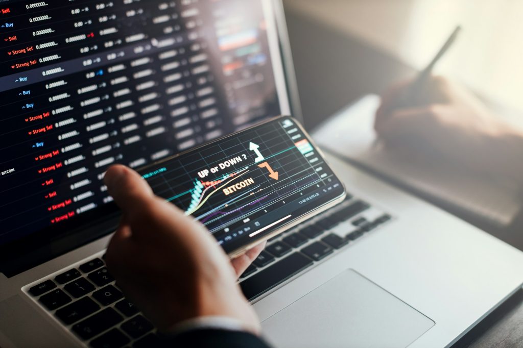 stockbroker using phone and laptop for profit gain analysis workplace